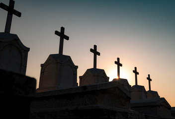 Cemetery or graveyard in the night with dark sky. Headstone and cross tombstone cemetery. Rest in peace concept. Funeral concept. Sadness, lament, and death background. Spooky and scary burial ground.