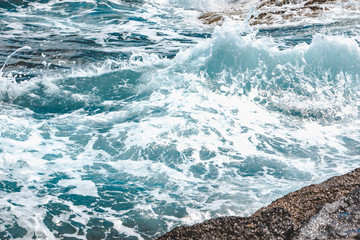 view of rocky seaside waves with white foam