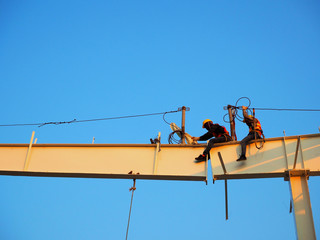 Man Working on the Working at height on construction site with blue sky