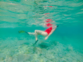 woman in red swimming suit underwater with snorkeling mask and flippers