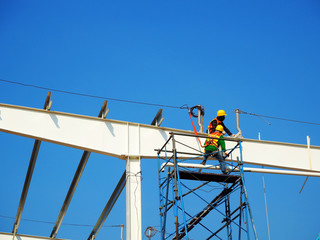 Man Working on the Working at height on construction site with blue sky