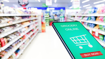 Smartphone mobile with grocery online on screen with blur supermarket background.