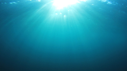Underwater sunburst. Blue water background and sunlight 