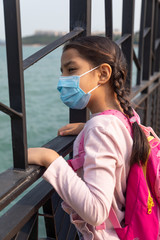 An 8 year old girl wears a mask during the coronavirus pandemic as she practices social distancing.