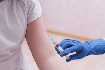 Doctor pediatrician injecting vaccine to cute girl