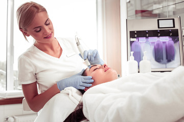 Obraz premium Beauty expert doing facial treatment for her constant client