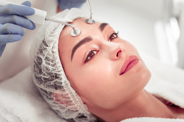 Dark-eyed woman having deep cleansing procedure for face
