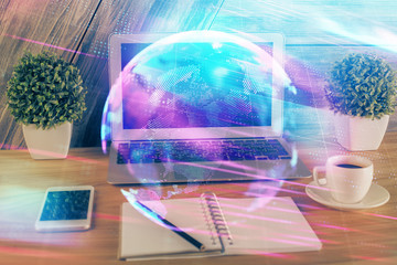 Computer on desktop in office with technology theme hologram. Multi exposure. Tech concept.