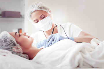 Beauty expert cleansing face using new ultrasound equipment