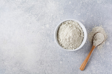 Closed collagen in a ceramic bowl on an old gray concrete background. Flat lay with copy space.
