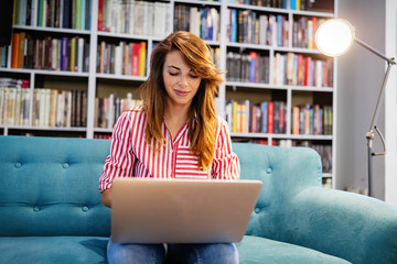 Portrait of happy student woman working on laptop