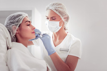 Professional cosmetologist doing mesotherapy injections for client