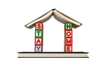 Books and letter blocks forming a house with the words STAY HOME isolated on white background; 
