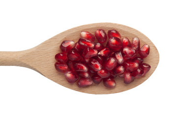 Pomegranate arils in a wooden spoon isolated on white background