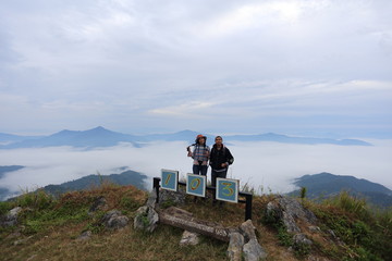 Woman and man standing and enjoying the view of Doi Pha Tang Chiang Rai, Thailand