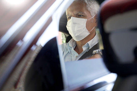 Man Driving Car And Wearing Face Mask During COVID19 Pandemic