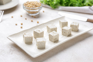 Plate with tasty tofu cheese on white background