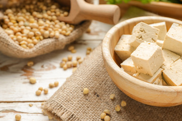 Bowl with tasty tofu cheese on table, closeup