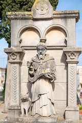 Fototapeta na wymiar Ein Prediger vor einem Grabstein auf einem Friedhof in Spanien