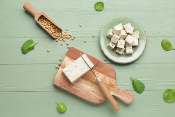 Tasty tofu cheese on color wooden background