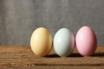 Colored eggs on a wooden stand on a gray background. Close up