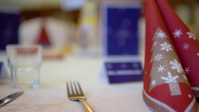 serviette with Christmas decoration on a set table with place card in background