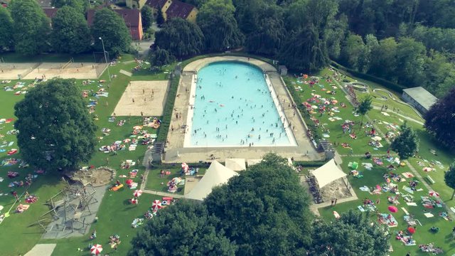 Drone shot from an outdoor swimming pool with people