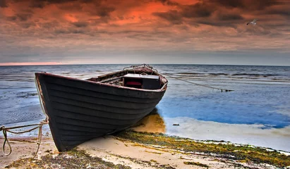 Fotobehang Kustlandschap met oude vissersboot bij dageraad, Oostzee, © sergei_fish13