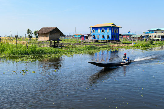Floating village on the lake. Houses on the lake in the water with floating garden. Wooden boat on the river.