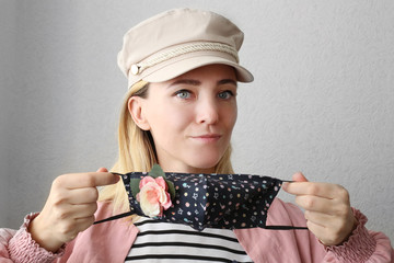 Stylish woman wearing black handmade face mask with flowers as decorative accessory element. Popular trend in fashion industry.