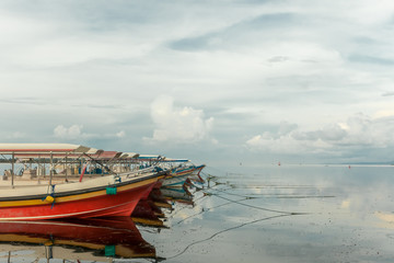 The boats are anchored without people. There are no tourists in Bali because of the Coronavirus. Landscape. Sea background