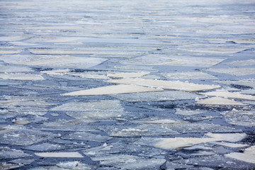 Melting ice on the lake. Ice drift, many small ice floes in the water.