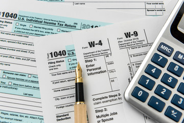 Fototapeta na wymiar Tax form, pen and calculator at office desk