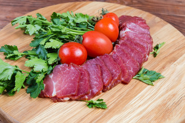 Dried-smoked pork neck on serving board in selective focus