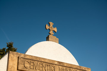 Ein Kreuz auf einer Kapelle  auf einem Friedhof in Spanien