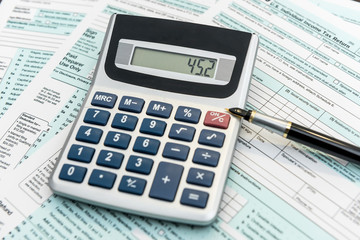 Time for tax, federal form with pen and calculator, office desk