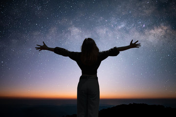Silhouette of young traveler open arm and watching the star and milky way on the top of the...