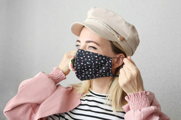 Stylish woman wearing black handmade face mask with flowers as decorative accessory element....