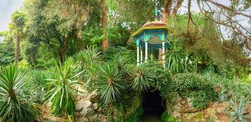 Gazebo over the grotto among the lawn with succulents