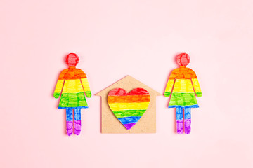 Lesbian couple figures with home symbol and rainbow heart. Homosexual family concept.