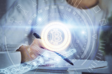 Cryptocurrency hologram over hands taking notes background. Concept of blockchain. Multi exposure