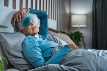 Mature Woman Wearing Cooling Blue Gel Eye Mask Against Dark Circles