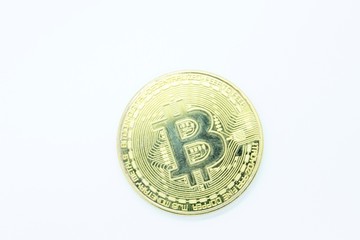 Physical gold bitcoin located on a white background