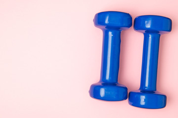 Obraz na płótnie Canvas Two blue of dumbbells Isolated on pink background