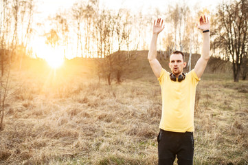 Attractive guy in headphones doing outdoor workout