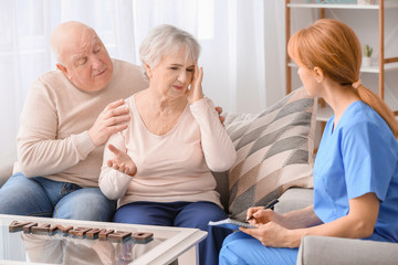 Obraz premium Elderly people suffering from mental disability and caregiver in nursing home