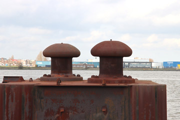 Rust-colored bollard for mooring ships in the port of Rotterdam  in the netherlands