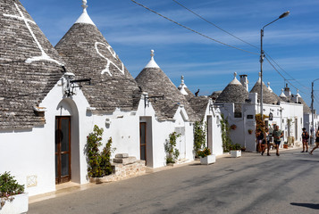 Tradtional white houses in Trulli village. Alberobello, Italy. The style of construction is...