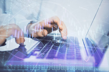 Double exposure of market chart with man working on computer on background. Concept of financial...