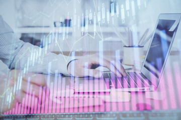 Multi exposure of stock market graph with man working on laptop on background. Concept of financial analysis.